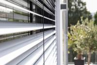 Nahaufnahme Raffstore mit Garten im Hintergrund