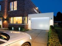 Auto fährt nachts in beleuchtete Garage