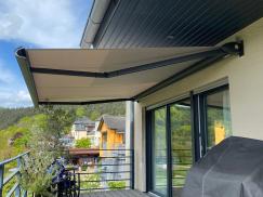 Gelenkarm-Markise auf großzügigem Balkon mit Grill