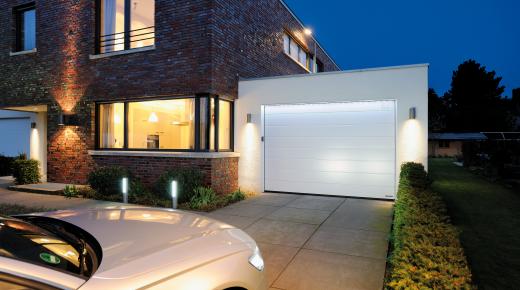 Auto fährt nachts in beleuchtete Garage