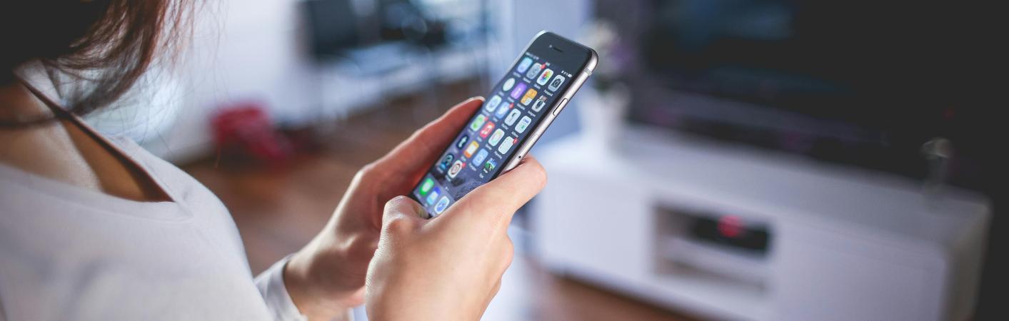 Smart Home Frau mit Handy im Wohnzimmer
